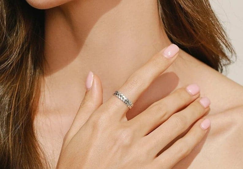 Frau hat einen silbernen Ring mit Zirkon an ihrem Zeigefinger