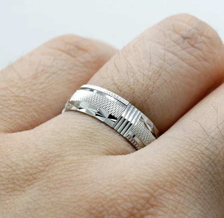 Der Mann hat einen Silber Eheringe an seinem Finger