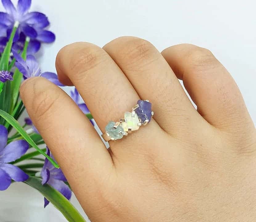 Frau hat einen Opal Ring an ihrem Mittelfinger