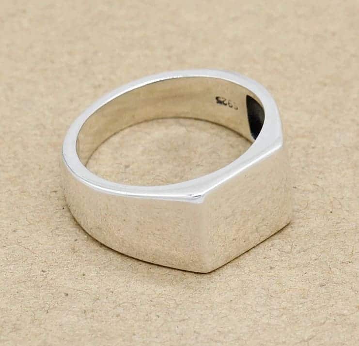 Einfacher silberner Ring auf gelbem Hintergrund