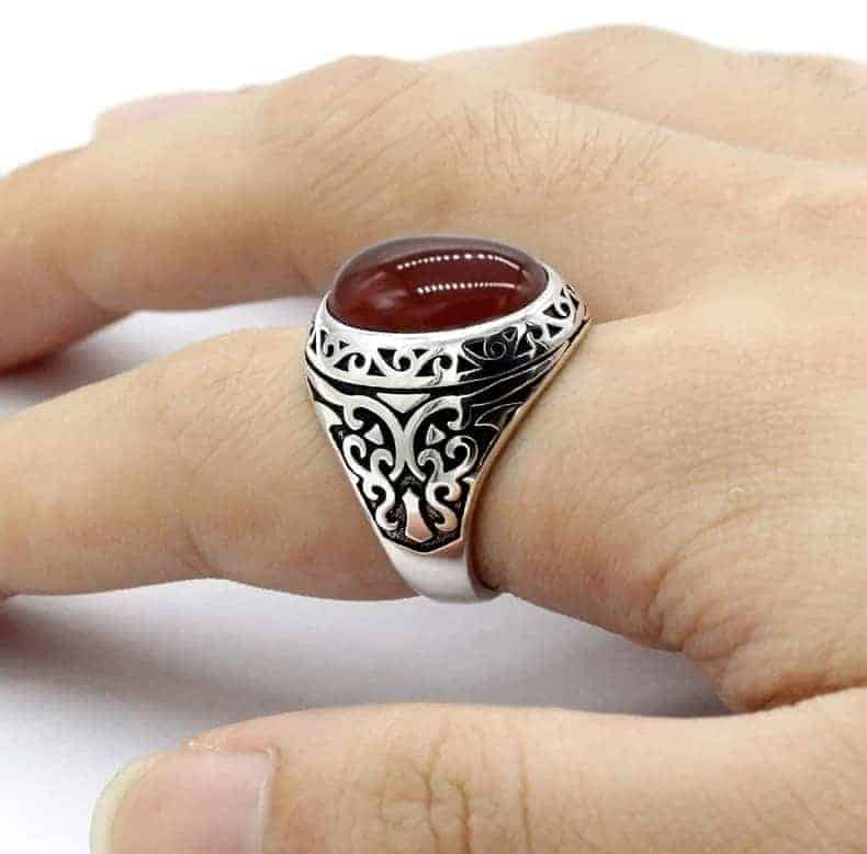 Der Mann hat einen Ring mit einem roten Achat Stein am Finger