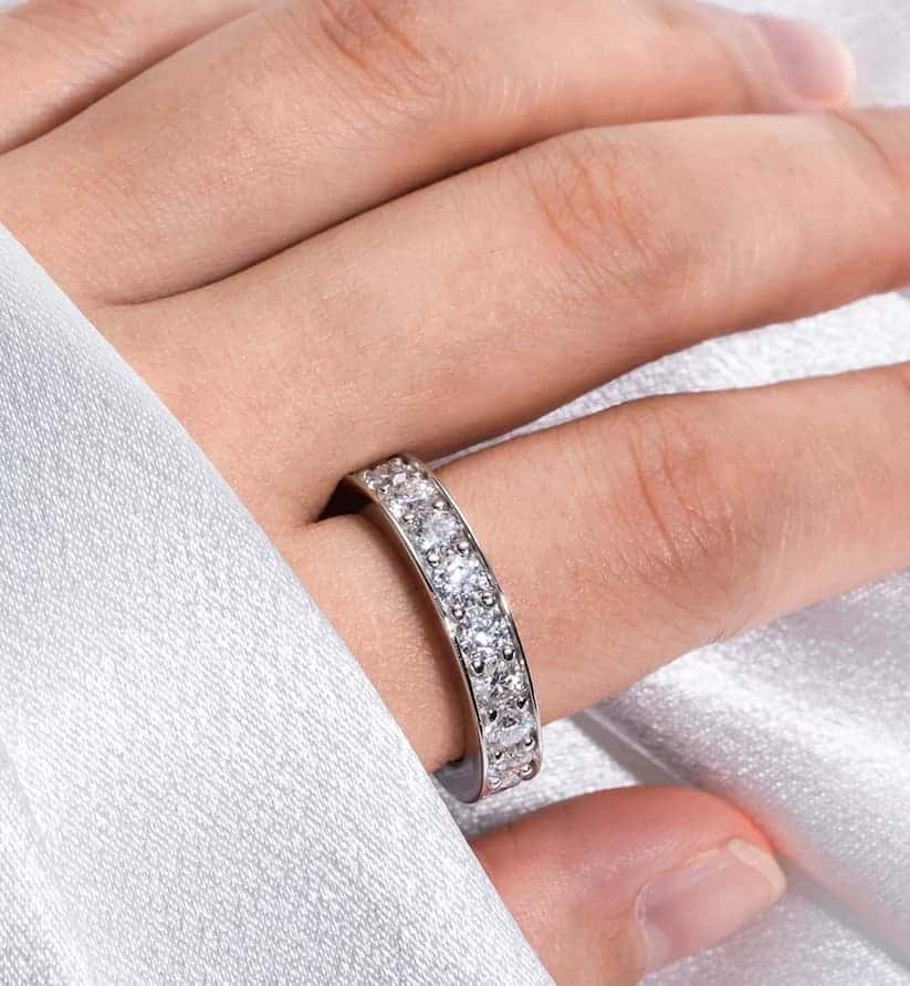 Die Frau hat Verlobungsring mit Silber Steinen an ihrem Finger