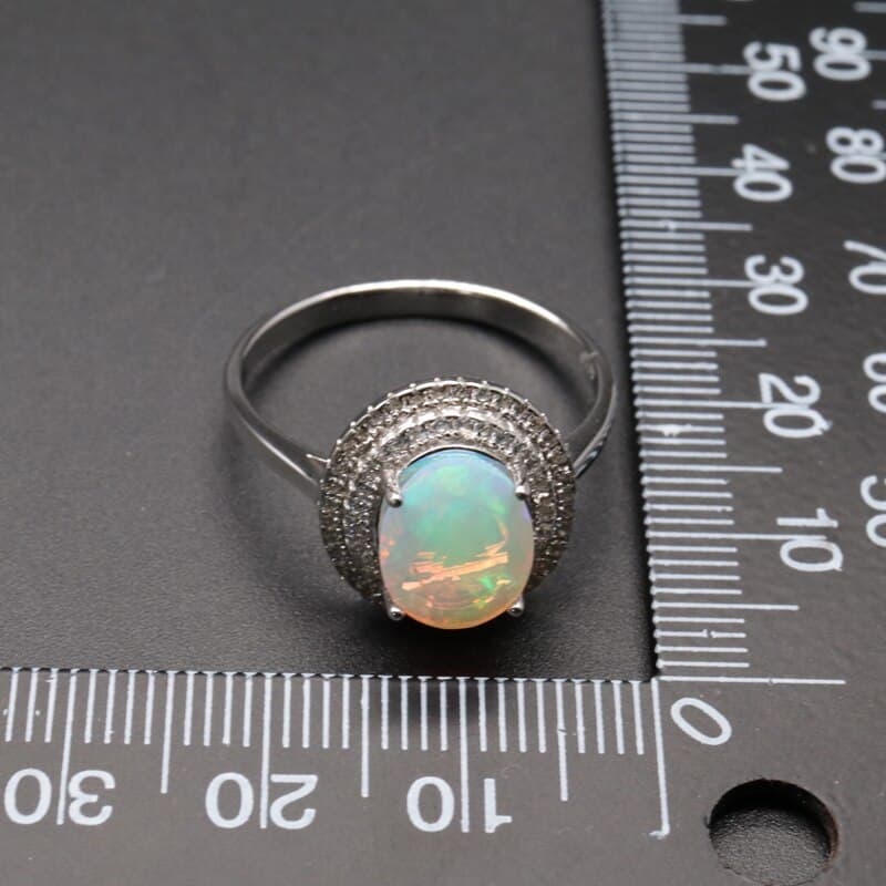 Opal Ring links neben dem Maßband