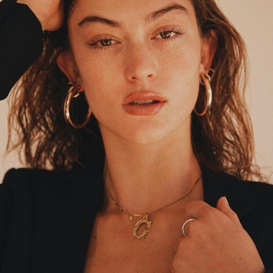 Frau trägt Buchstabenhalskette