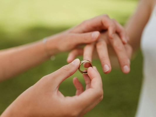 Mann steckt seiner Frau einen Ehering an