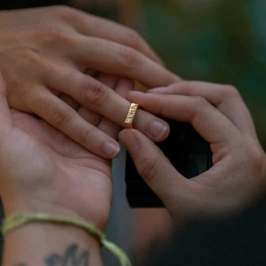 Frau-steckt-ihrem-Mann-einen-goldenen-Ehering-an-den-Finger