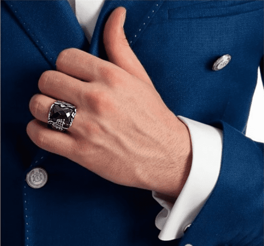 Der Mann posierte und hielt seine Jacke mit seiner beringten Hand.