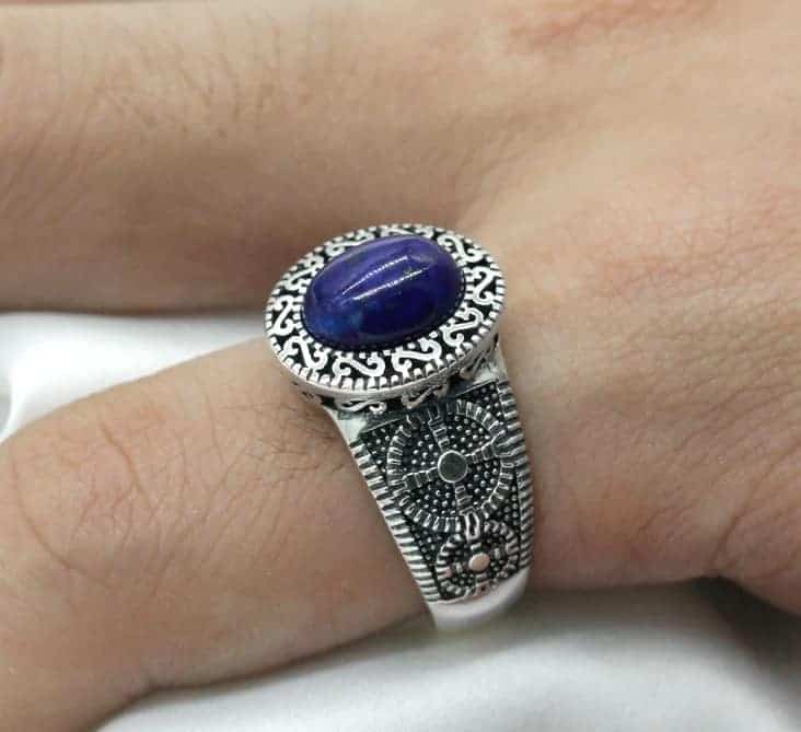 Der Mann hat einen Ring mit einem blauen Stein am Finger