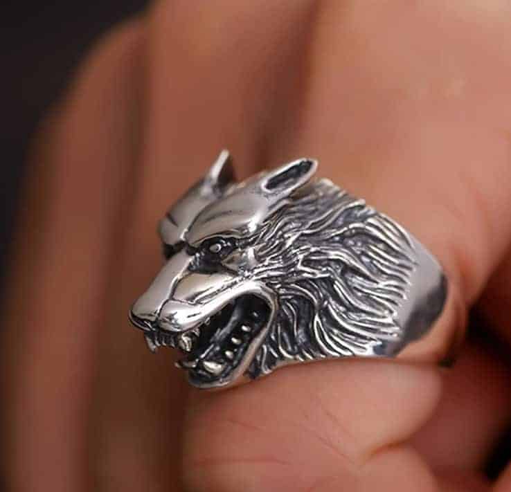 An seinem Zeigefinger trägt er einen silbernen Ring mit Wolfskopf.