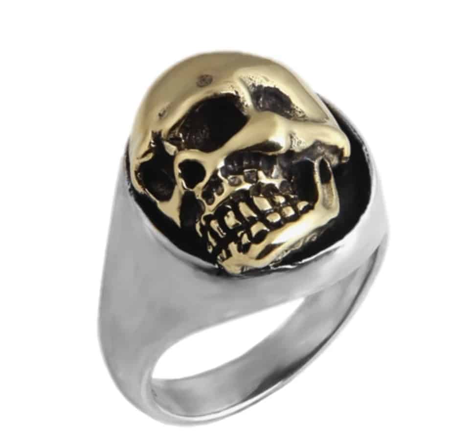 Silberner Ring mit Schädel Muster in Gold Farbe auf weißem Hintergrund