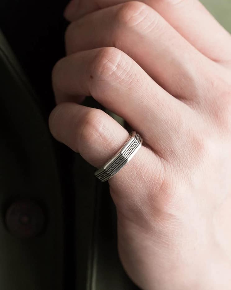 Der Mann trägt einen silbernen Ring an seinem kleinen Finger