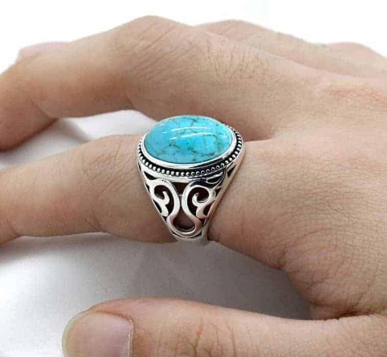 Der Mensch hat einen indischencshmuck Ring aus blauem Stein an seinem Finger