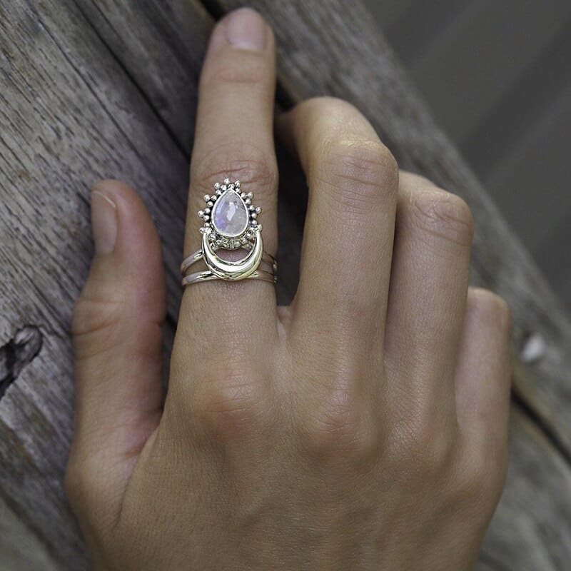 Frau hat Ring mit Mond und Mondstein am Zeigefinger