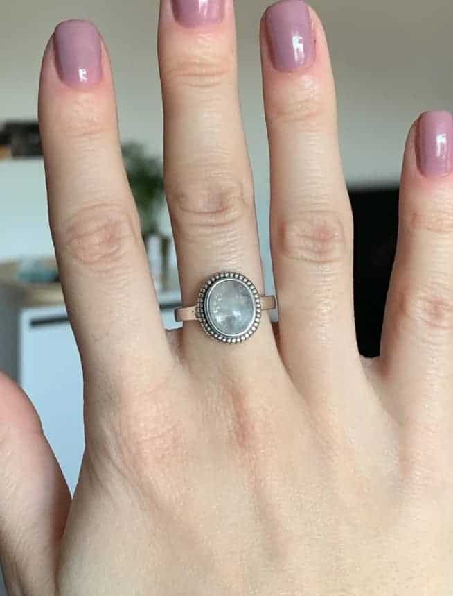 Frau hat einen Mondstein Ring an ihrem Mittelfinger