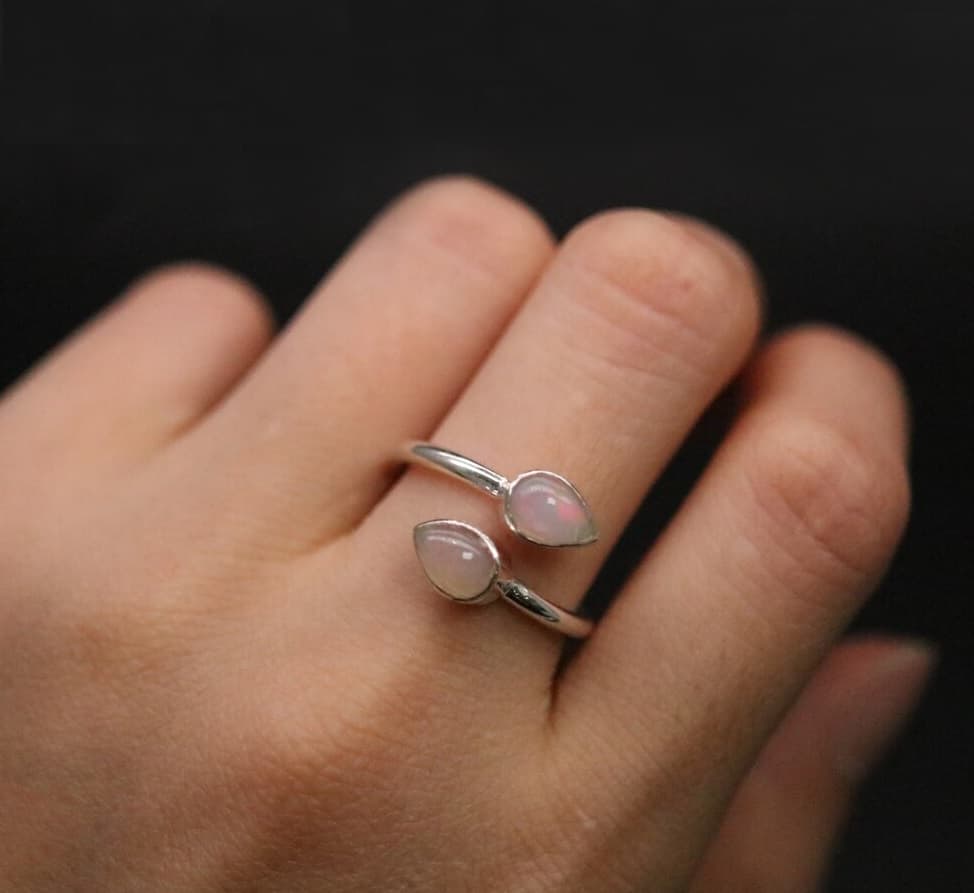 Frau hat einen Opal Ring an ihrem Mittelfinger