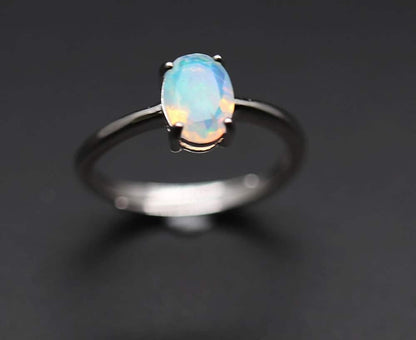 Ein feiner Silberring mit einem leuchtend weißen Opal darauf