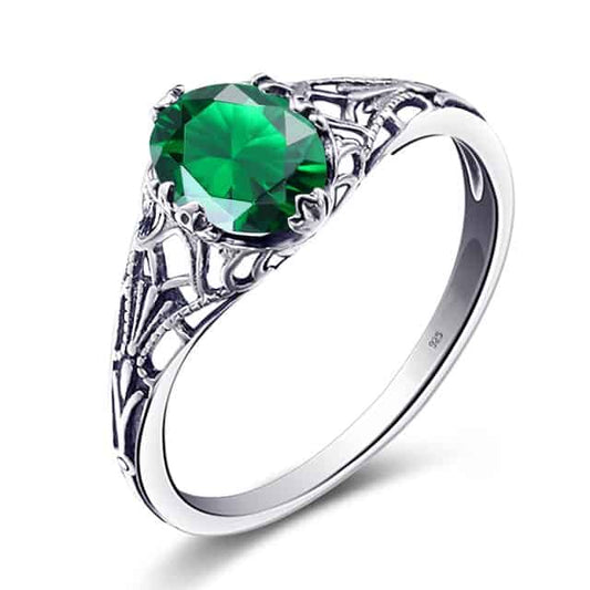 Silberring-für-damen-mit-kleinem-grünen-Smaragd Stein-auf-weißem-Hintergrund