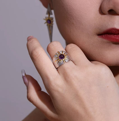 Die Frau hat einen silbernen Ring mit Amethyst am Mittelfinger