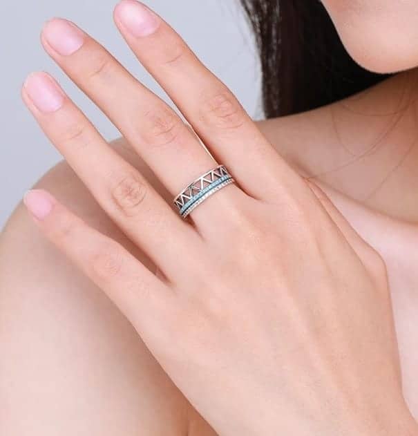 Frau hat einen silbernen Ring mit Türkis Stein auf ihrem Mittelfinger
