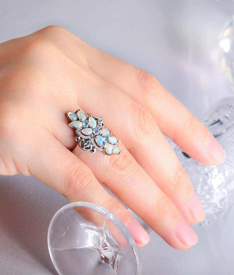 Frau hat einen Opal Ring an ihrem Ringfinger