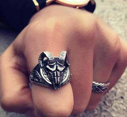 Der Mensch hat einen Widder-gemusterten Silberring an seinem Zeigefinger