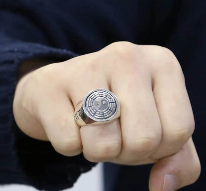 Der Mann hat einen silber Ring mit einem Yin-Yang-Zeichen am Ringfinger