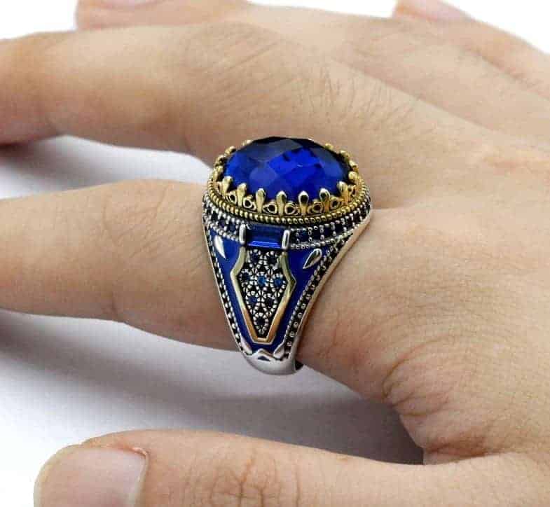 Der Mann hat den Blauer Edelstein Ring am Finger